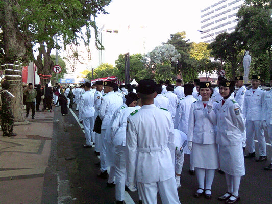A group of men in white uniforms walking down a street