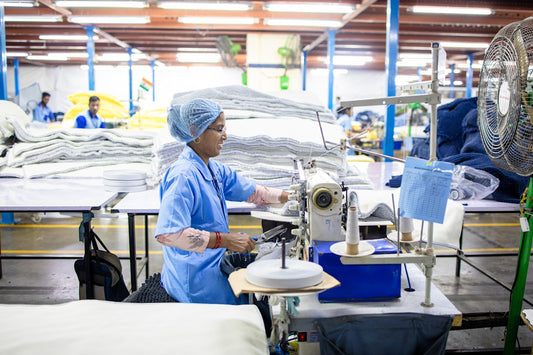 A woman sews clothing in a textile factory.