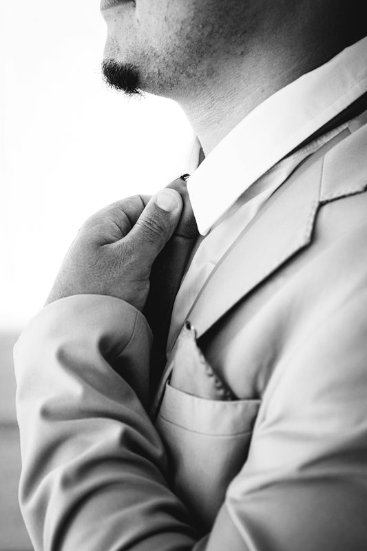 Man adjusting his suit collar and tie